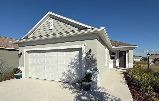 single story home with driveway, an attached garage, and stucco siding