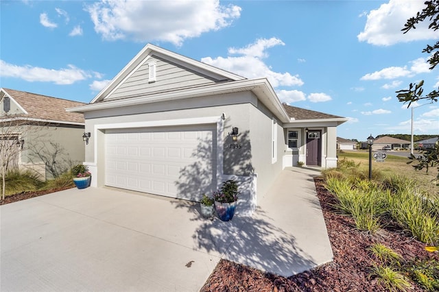 ranch-style house with an attached garage, concrete driveway, and stucco siding