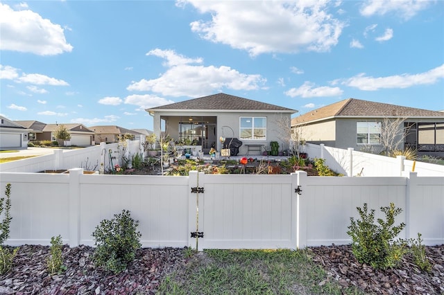 exterior space featuring a fenced front yard, a gate, a residential view, and stucco siding