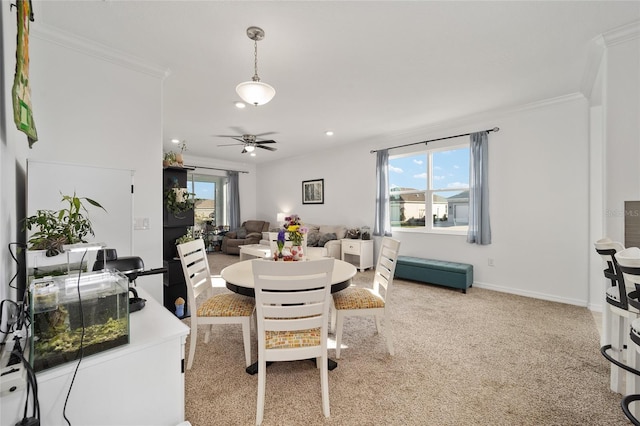 dining room with a wealth of natural light, light carpet, crown molding, and baseboards