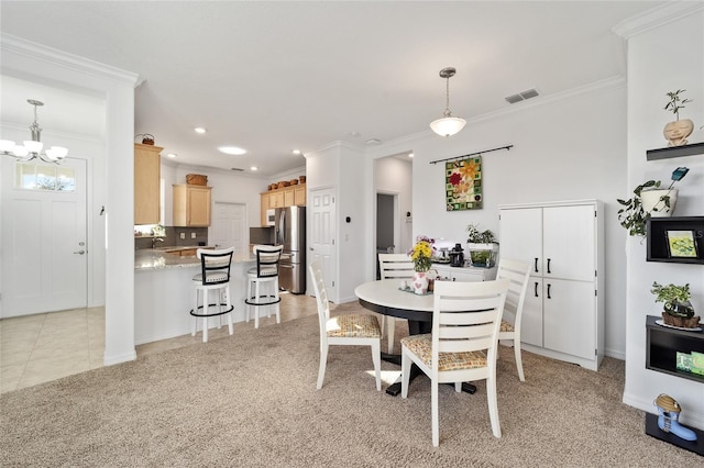 dining room with ornamental molding, light colored carpet, and visible vents