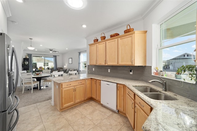 kitchen featuring backsplash, a sink, stainless steel fridge, dishwasher, and a peninsula