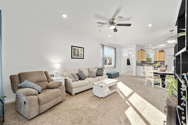 living area featuring crown molding, recessed lighting, and light colored carpet