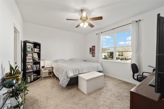 bedroom featuring a ceiling fan, light colored carpet, and baseboards