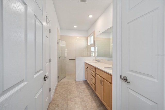 full bath featuring double vanity, a stall shower, tile patterned flooring, a sink, and recessed lighting