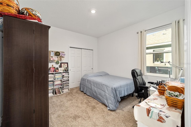 bedroom featuring light carpet and a closet