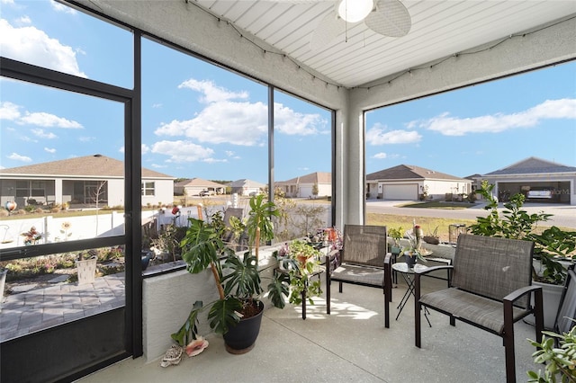 sunroom / solarium with a ceiling fan and a residential view