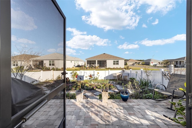 view of patio / terrace with a residential view, a fenced backyard, and a garden