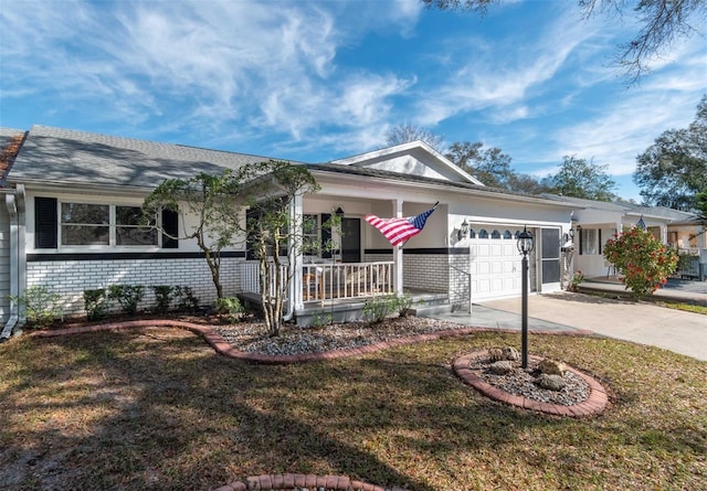 single story home featuring a porch, a garage, brick siding, concrete driveway, and a front yard