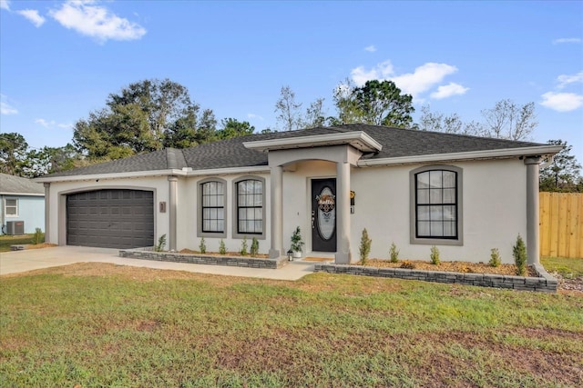 single story home featuring stucco siding, an attached garage, fence, driveway, and a front lawn