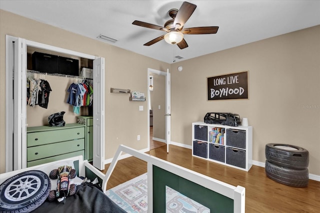 bedroom with baseboards, a closet, visible vents, and wood finished floors