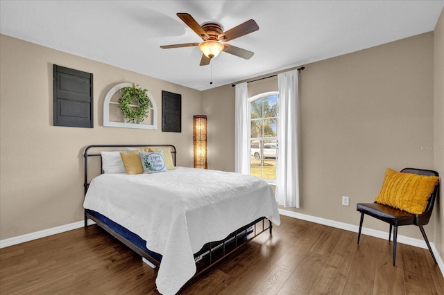 bedroom featuring a ceiling fan, baseboards, and wood finished floors