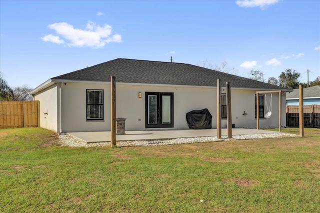 rear view of house with a yard, fence, stucco siding, and a patio