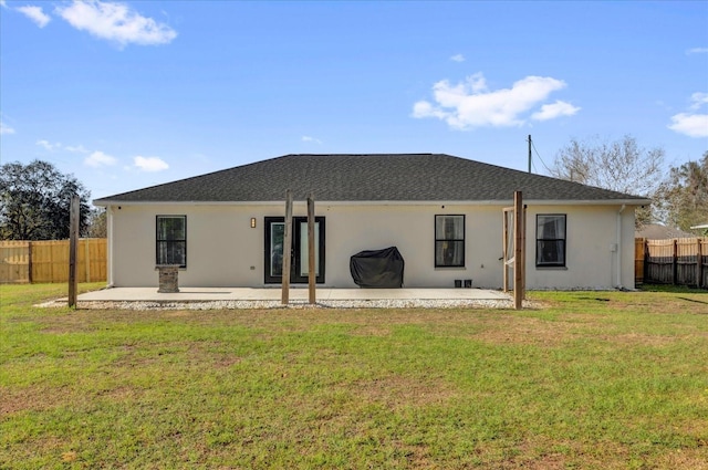 rear view of property featuring a yard, stucco siding, a patio, and fence