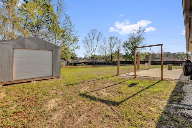 view of yard featuring fence, a patio, and an outdoor structure