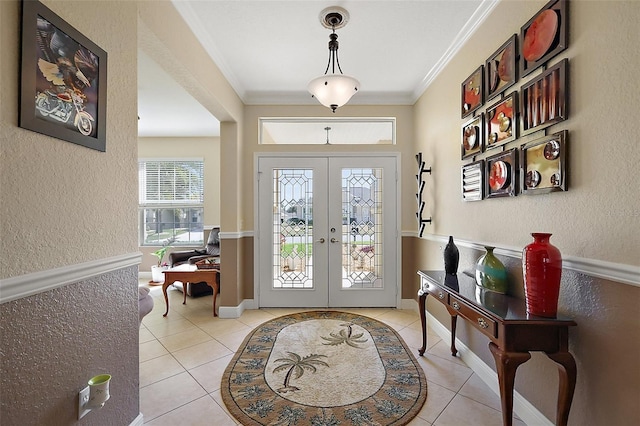 entrance foyer featuring ornamental molding, french doors, and light tile patterned floors