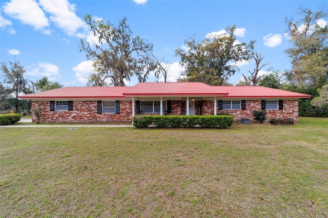 single story home featuring covered porch, metal roof, a front lawn, and brick siding