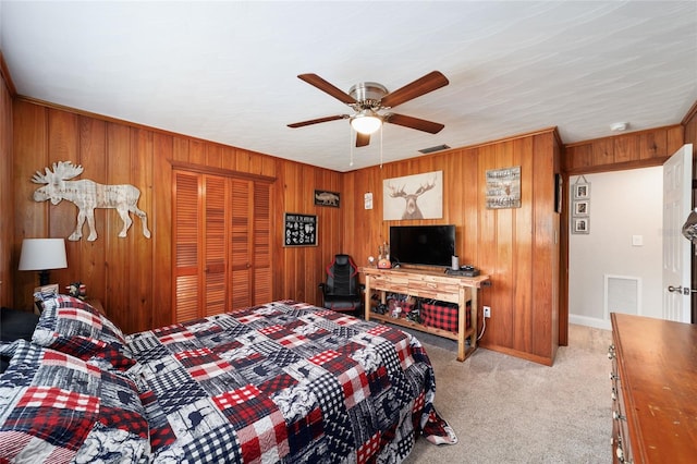 bedroom with wood walls, a closet, visible vents, and light colored carpet