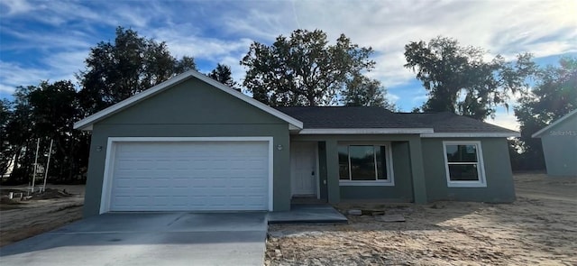 single story home with a garage, driveway, and stucco siding