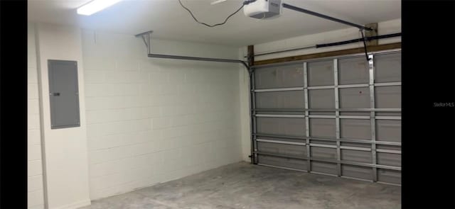 garage featuring a garage door opener, concrete block wall, and electric panel