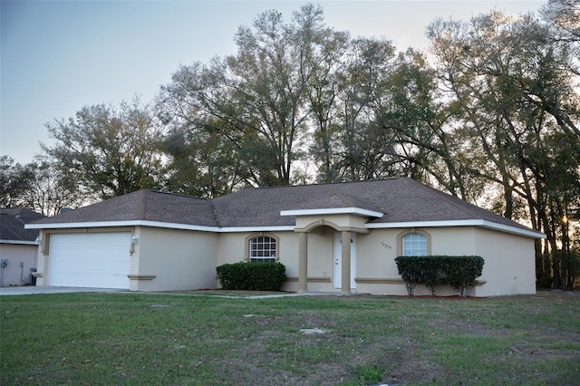 ranch-style home with an attached garage, driveway, a front lawn, and stucco siding