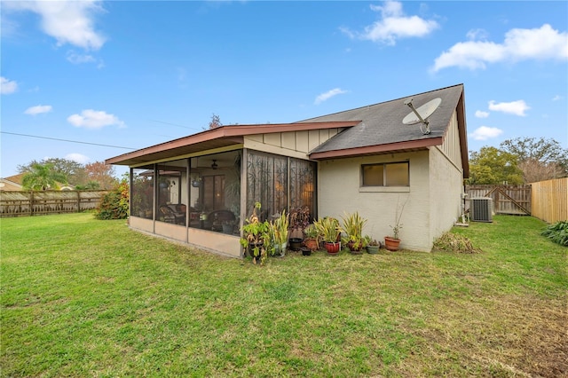 rear view of property featuring a sunroom, a fenced backyard, cooling unit, and a yard