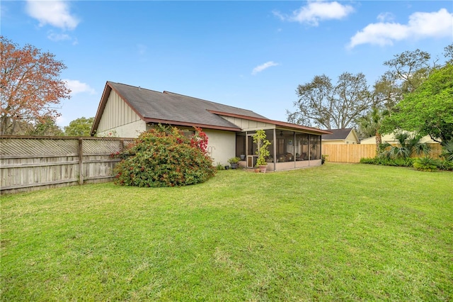 back of house with a sunroom, a fenced backyard, and a lawn