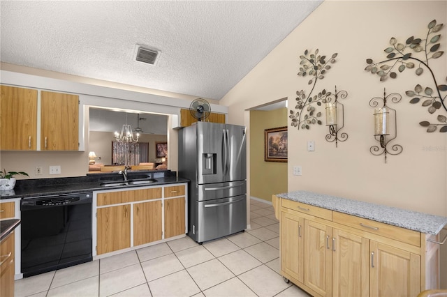 kitchen with black dishwasher, lofted ceiling, dark countertops, a sink, and stainless steel fridge