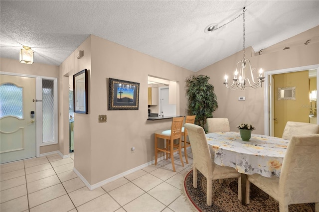 dining room featuring lofted ceiling, light tile patterned floors, and a textured ceiling