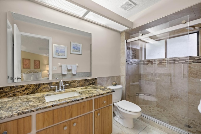 ensuite bathroom featuring ensuite bathroom, toilet, visible vents, tile walls, and a shower stall