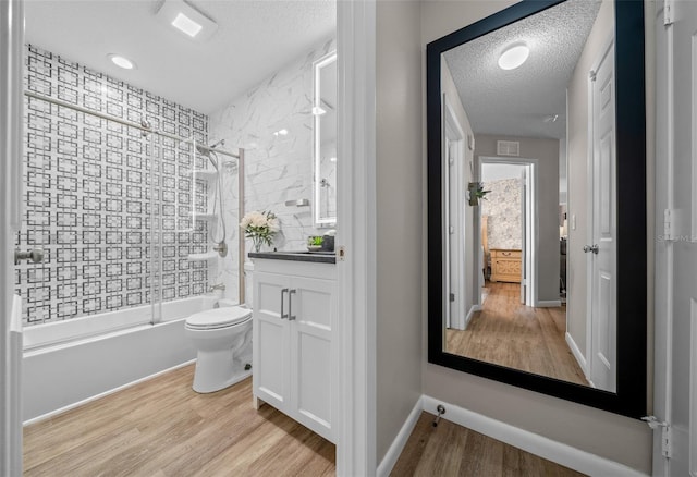 bathroom featuring vanity, a textured ceiling, shower / bathtub combination, and wood finished floors