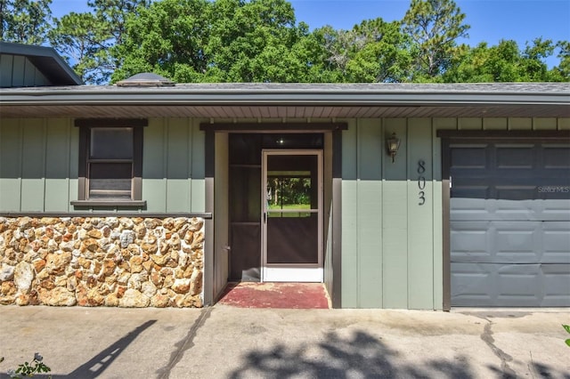 doorway to property featuring a garage and board and batten siding