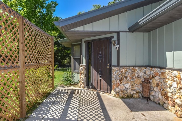 property entrance featuring stone siding and board and batten siding