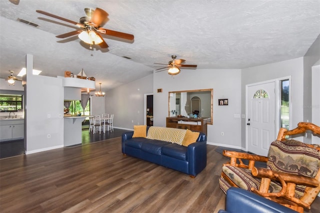 living room with lofted ceiling, a textured ceiling, visible vents, and wood finished floors