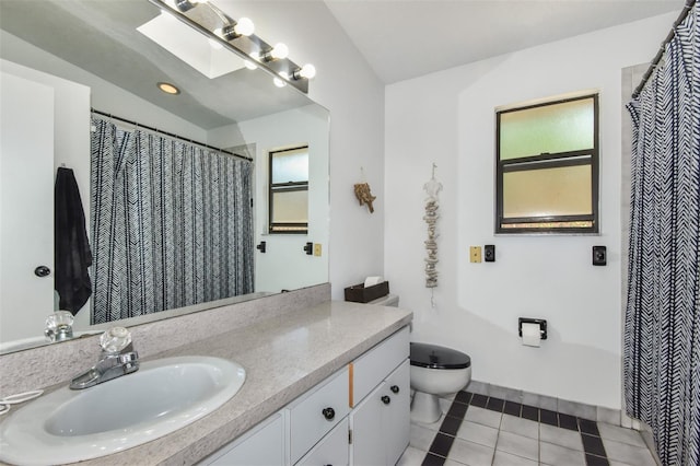 bathroom featuring tile patterned flooring, toilet, a skylight, vanity, and a wealth of natural light