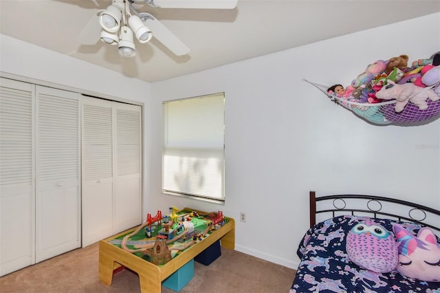 bedroom featuring baseboards, ceiling fan, a closet, and light colored carpet