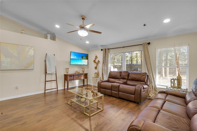 living area featuring ornamental molding, vaulted ceiling, baseboards, and wood finished floors