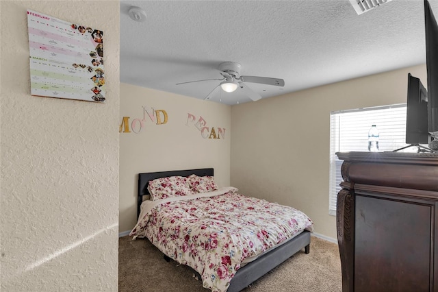 bedroom featuring carpet, visible vents, a textured wall, a ceiling fan, and a textured ceiling