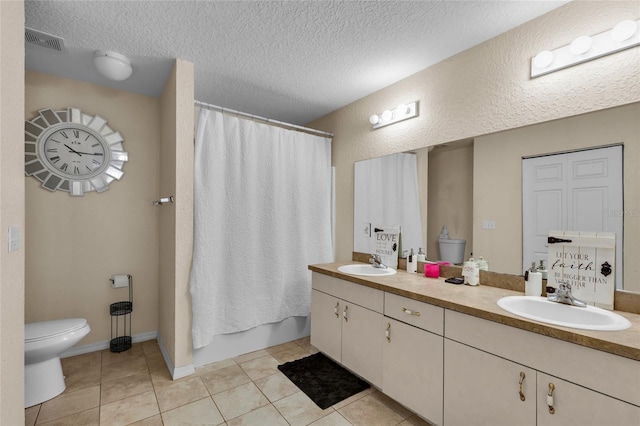 bathroom with toilet, tile patterned flooring, visible vents, and a sink