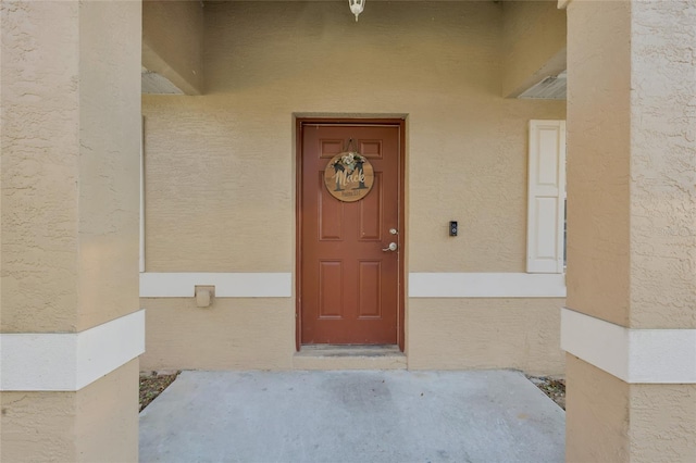 view of exterior entry with stucco siding