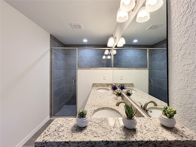 bathroom featuring a stall shower, a sink, and visible vents