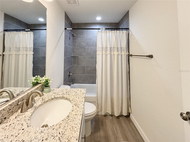 full bathroom featuring toilet, shower / bath combo, vanity, wood finished floors, and baseboards