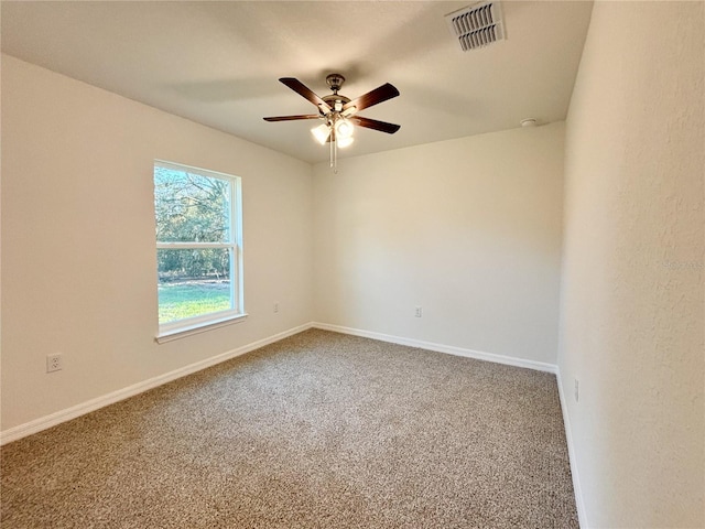 spare room with ceiling fan, carpet, visible vents, and baseboards