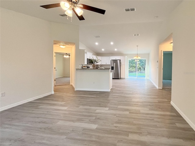 unfurnished living room featuring lofted ceiling, a ceiling fan, baseboards, visible vents, and light wood-style floors