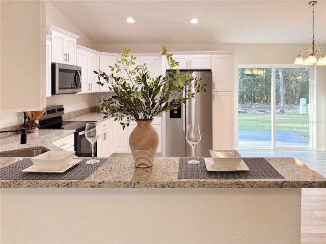 kitchen with appliances with stainless steel finishes, recessed lighting, white cabinets, and light stone countertops