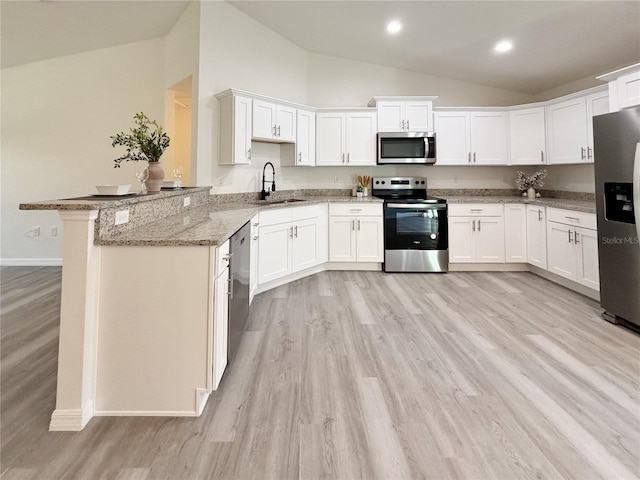 kitchen featuring white cabinets, light stone counters, stainless steel appliances, and a sink