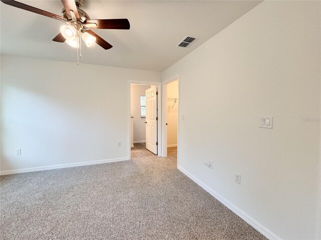 spare room featuring baseboards, ceiling fan, visible vents, and light colored carpet