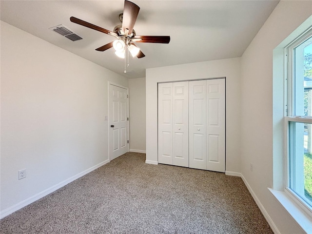 unfurnished bedroom with carpet floors, a closet, visible vents, and baseboards