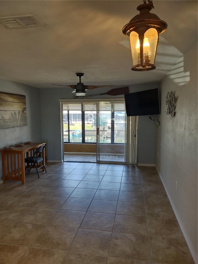 unfurnished room featuring baseboards, ceiling fan, visible vents, and tile patterned flooring