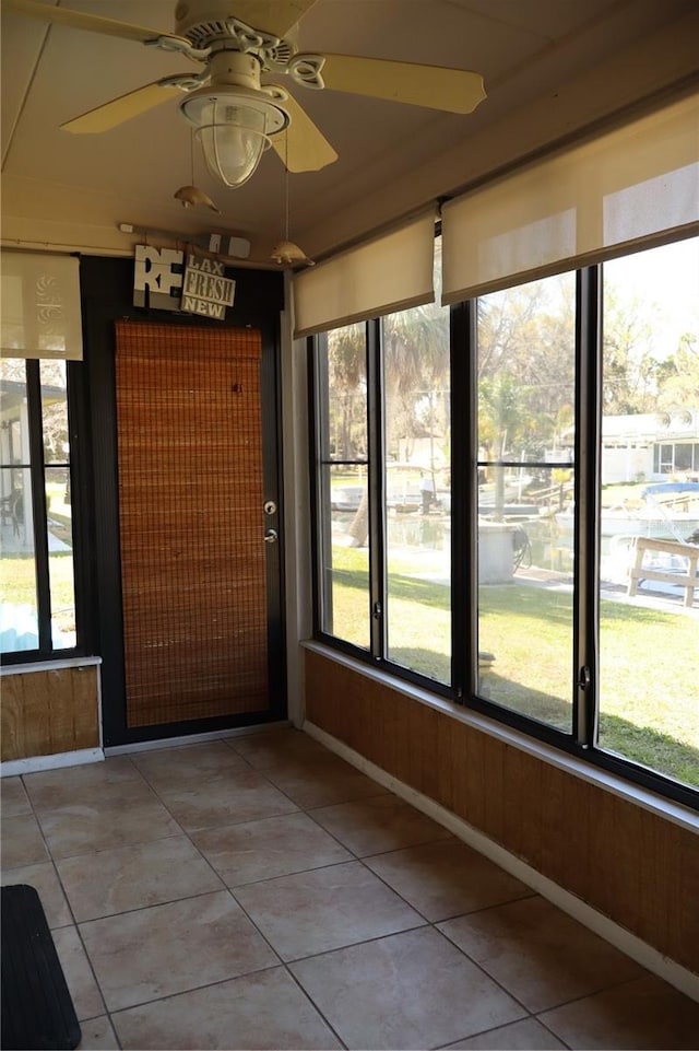 unfurnished sunroom featuring ceiling fan